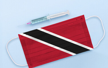 Flag of Trinidad and Tobago on Medical protective Surgical mask and vaccine. Coronavirus vaccine and vaccination concept. 