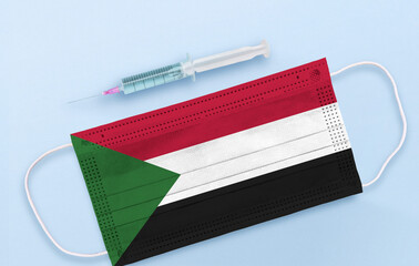 Flag of Sudan on Medical protective Surgical mask and vaccine. Coronavirus vaccine and vaccination...