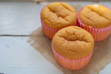 A homemade Mamon cakes on a a white wooden table with blank for copy space.
