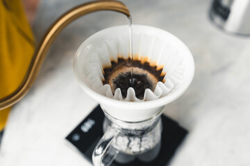 Drip coffee, barista pouring water on coffee ground with filter