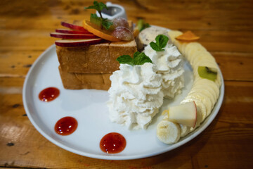 ice cream set with honey toast set on white dish put on wood table