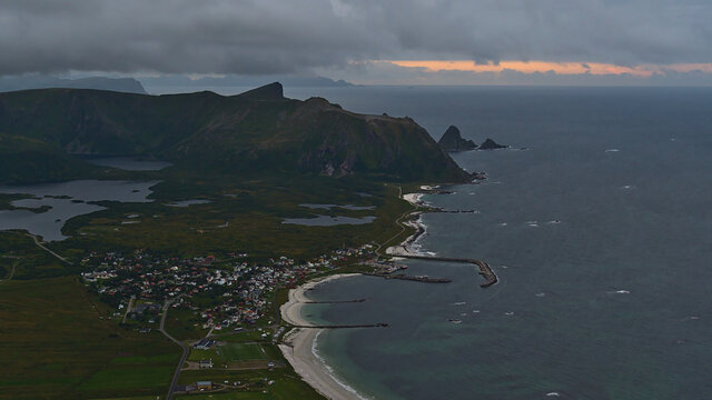 Beautiful aerial view of small fishing village Bleik located on the coast of Norwegian Sea in the northwest of And&oslash;ya island, Vester&aring;len, Norway with beach and rugged mountains on cloudy day.