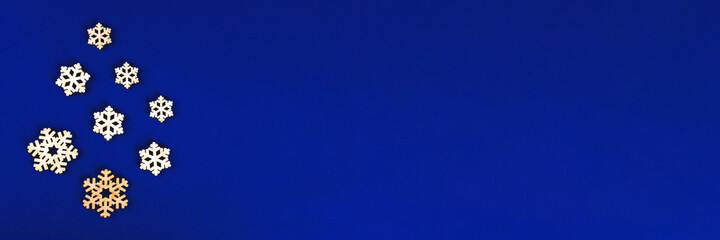 The zero waste new year concept as the handmade wooden snowflakes on the blue background, banner.