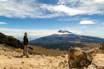 Man reached the top of the mountain.hiker observes the orizonte in the chasm of the Iztaccihuatl volcano Popocatepetl National Park, Mexico. concept Sport and active life