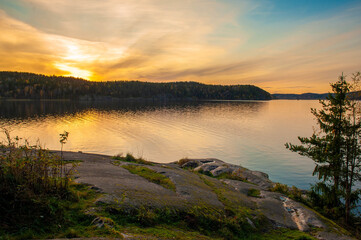 Fototapeta na wymiar Wonderful sunset on the lake. View of Lake Ladoga in the autumn evening. Russia, Karelia.