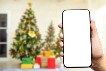 Close-up of female use smartphone blurred images with Colorful balls on Green Christmas tree...