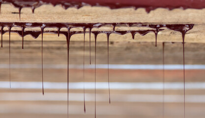 Drops of brown paint dripping from the wooden ceiling.