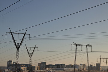 high-voltage towers against the background of the city