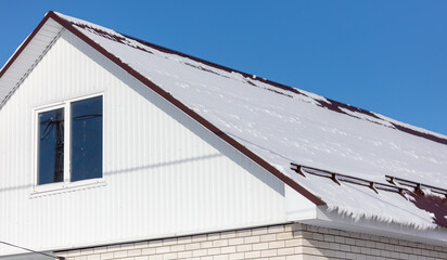 Snow on the roof of the house.