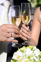 The bride and groom hold champagne glasses in their hands