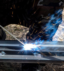 A worker welds metal at a construction site. Technology