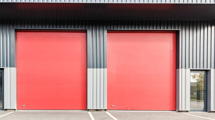 grey Warehouse building with two industrial red door