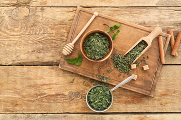 Bowls with dry green tea on wooden table