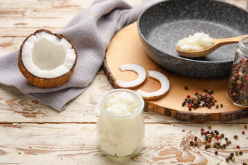 Composition with tasty coconut oil for cooking on light wooden background
