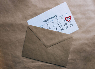 Valentine's day background. Valentine's day february calendar and envelope with pen on craft background.