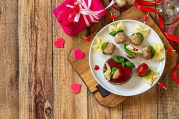 Valentines day or birthday romantic dinner. Pasta cooked in the form of canapes, meatballs, served with tomato sauce.