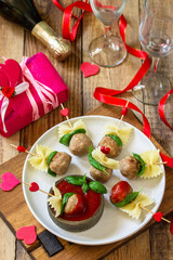 Valentines day or birthday romantic dinner. Spaghetti cooked in the form of canapes, meatballs, served with tomato sauce.