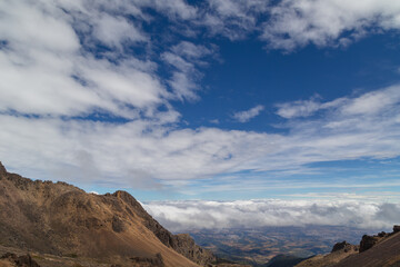 High angle shot of forest on hills covered with clouds