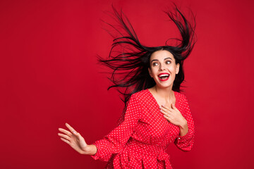 Portrait of attractive cheerful lady model having fun party wind blowing hairstyle isolated on bright red color background
