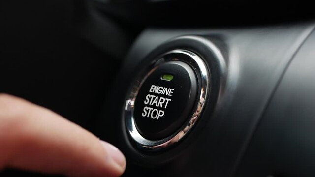 Man is pressing the button engine start in car. Start car engine by pushing a button. Close-up.