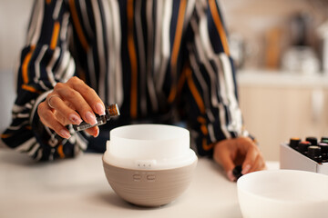 Holding bottle with essential oil for diffuser Aroma health essence, welness aromatherapy home spa fragrance tranquil theraphy, therapeutic steam, mental health treatment
