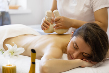 Woman enjoying body massage at spa club