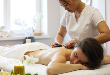 Obraz na płótnie Canvas Hot stone massage at spa salon