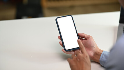 Close up view of male hands using smartphone with blank screen for graphics display montage.