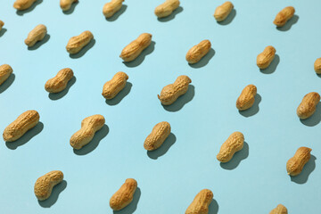 Flat lay with unshelled peanut on blue background