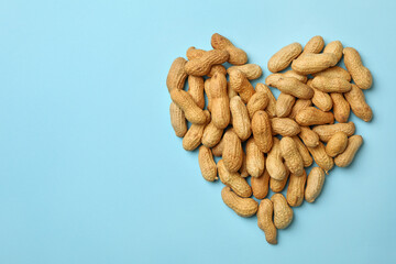 Heart made of peanut on blue background