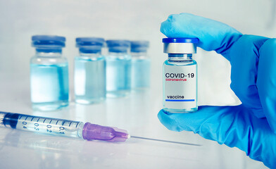 Handles holding Coronavirus vaccine and syringe prepares for injection,medicine and drug concept.