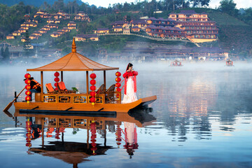 Asian woman wearing chinese traditional dress on Yunan boat at Ban rak thai village in mae hong son...
