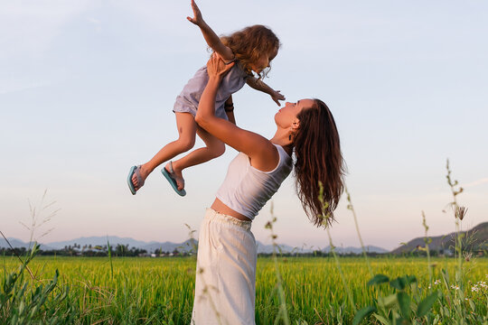 Young Mother and daugther play near rice field, nature, travel