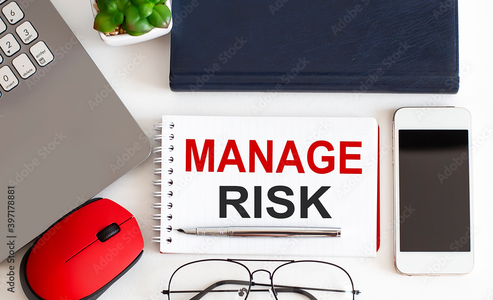 Poster manage risk text written on a notebook with pencils