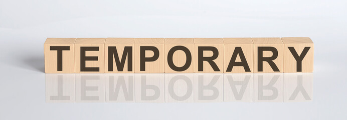 Temporary word written on cube shape wooden blocks on white background