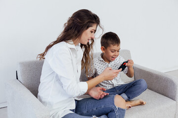 Mom and son play smartphone games on the couch