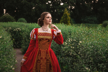 beautiful young woman in a red medieval dress is standing in the park, fantasy princess © Анастасія Смирнова