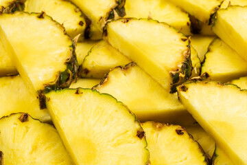 Pineapple juicy yellow slices background. Top view.