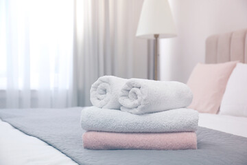 Fototapeta na wymiar Soft clean towels on bed in room