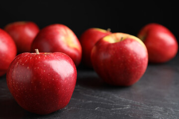 Fototapeta na wymiar Fresh ripe red apples on black table, closeup