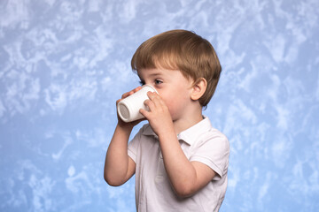 little boy drinks water from a disposable cup of cornstarch. ecologicaly clean. replacing plastic...