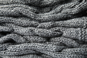 Soft grey knitted plaid as background, closeup