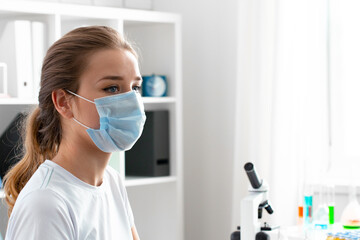 Woman patient in medical mask sitting in doctor's cabinet