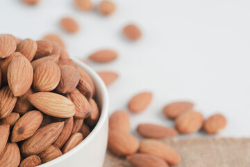 The almonds are in a white bowl.Almond concept with copyspace.