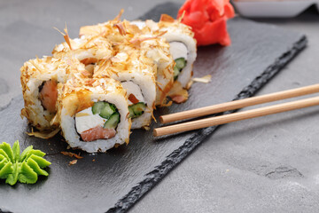 Sushi roll with tuna shavings on plate close up