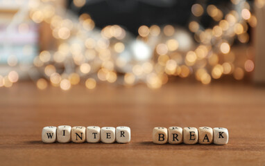 Cubes with phrase Winter Holidays and blurred Christmas decor on background. Space for text