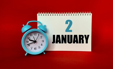 January 2 on a white Notepad .Next to it is a blue clock on a red background.Calendar for January .