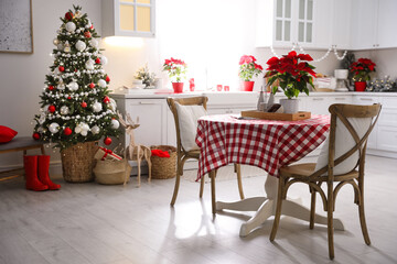 Fototapeta na wymiar Beautiful kitchen interior with Christmas tree and festive decor