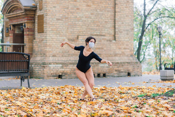 Fashion portrait of sexy woman in face mask and bodysuit in autumn park. Pandemic, coronavirus