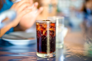 Blurred abstract background of hands eating on a table like seafood (Baked shrimp vermicelli, deep fried sea bass with fish sauce, yum squid) eaten alongside soft drinks, while on vacation with family